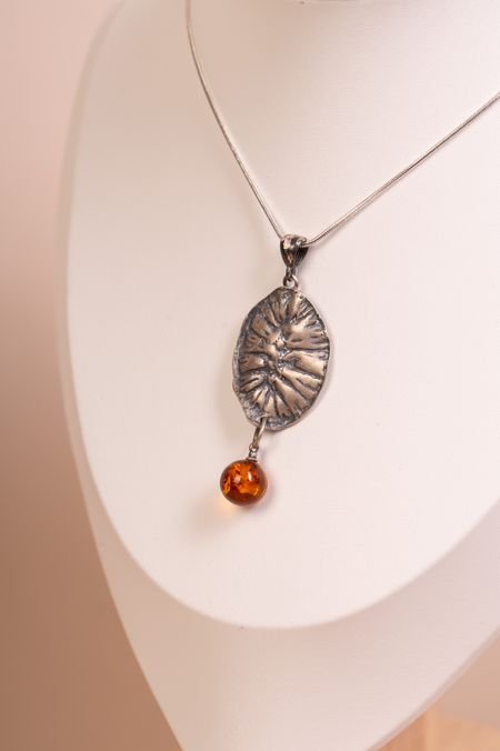 Handmade silver pendant with an amber sphere