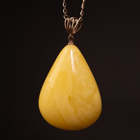 Pendant with honey-colored Baltic amber and a gold clasp
