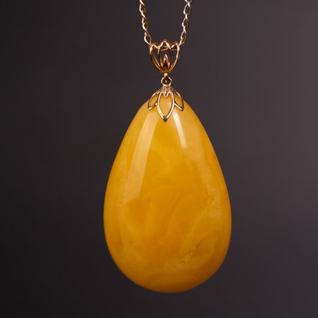 Pendant with a gold clasp and natural honey-colored amber
